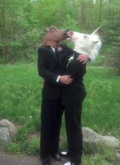 two men in suits are kissing and one is wearing a dog's head on his shoulders