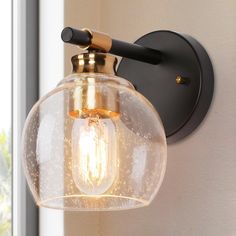 a light that is on the side of a wall with a glass ball hanging from it