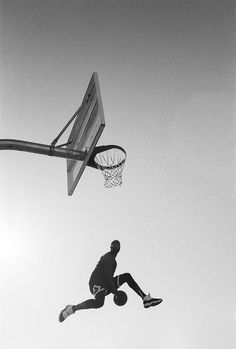 a man jumping up into the air with a basketball in front of him and an object flying through the air