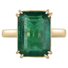 Displayed is a classic emerald solitaire engagement or right-hand ring. This spectacular piece features a remarkable 7.25-carat, natural emerald cut emerald from the origins of Zambia. The center stone showcases a rich green color that enthralls at first glance. Minor imperfections are normal in earth-mined gems though this gem is very eye clean. Carefully set in secure, double prong 18K yellow gold setting. Setting Style: Prong Setting Material: 18K Yellow Gold Main Stone: Emerald Shape: Emerald Cut Weight: 7.25-Carats Clarity: Transparent Color: Deep Green Luster: Very Good Treatments: Natural, Oiling Origin: Zambia Estimated Retail Value: $24,190.00 USD Emerald Gold Ring, Engagement Ring Classic, Ring Emerald Cut, Claw Prong, Ring Emerald, Etsy Gold Ring, Right Hand Rings, Hand Ring, Colombian Emeralds