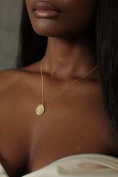 THE QUEEN of Sheba Bar Coin Necklace is handcrafted based on an authentic coin using the traditional lost-wax casting technique. The design features an image of the powerful Queen Makeda in a voluminous headwrap and jewels. It is said that she traveled to Jerusalem "with a very great retinue, with camels bearing spices, and very much gold, and precious stones" to visit King Solomon to "prove him with hard questions". She left pregnant with his child, Menelik the I, from whom the Ethiopian dynast Yellow Gold Metal Coin Necklace, Medallion Necklace With Coin Pendant For Rituals, Medallion Necklaces With Coin Pendant For Rituals, Coin Pendant Medallion Necklace For Rituals, Rituals Medallion Necklace With Coin Pendant, Blessing Coin Pendant Medallion Jewelry, Symbolic Gold Coin Necklace, Symbolic Brass Coin Necklace, Ceremonial Gold Coin Necklaces