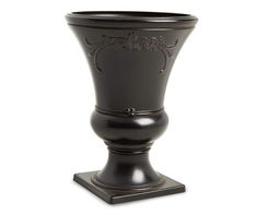 a black vase sitting on top of a wooden stand