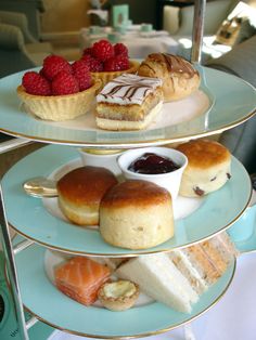 three tiered trays filled with pastries and desserts on top of each other