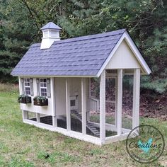 a white chicken coop with a blue roof