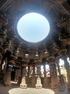 the sun shines brightly through an ornately carved ceiling in a stone structure with columns and pillars