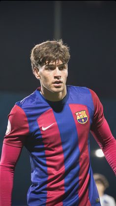 a young man in a blue and red soccer uniform