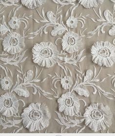 an embroidered fabric with white flowers on it