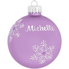 a purple ornament with white snowflakes on the bottom and name written on it