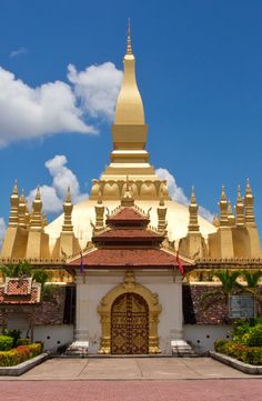 a large golden building sitting on top of a lush green field