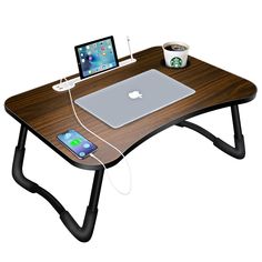 a laptop computer sitting on top of a wooden desk next to a cup of coffee