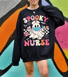 Spooky Nurse Sweatshirt Celebrate Halloween with a Dose of Fun and Fright 🩺👻 👻 Description: For those who save lives by day and embrace the spooky season by night, our "Spooky Nurse" Sweatshirt is the perfect blend of Halloween fun and professional pride! Whether you're a healthcare hero or just love the eerie vibe, this sweatshirt adds a playful, spooky touch to your Halloween wardrobe. 🛠️ Made to Order: Your "Spooky Nurse" Sweatshirt is crafted just for you! Every piece is made to order, e Nursing Sweatshirt, Cute Nurse, Er Nurse, Halloween Nurse, Nurse Sweatshirt, Autumn Night, Sweatshirt Halloween, Sweatshirt Cute, Halloween Shirts