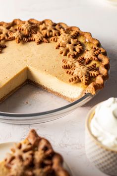 there is a pie on the table next to some cupcakes and a glass plate