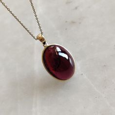 ITEM DESCRIPTION: >> The Pendant is made from Solid 14K Yellow Gold. Gemstone used is absolutely natural and ethically sourced. >> Natural Garnet in cabochon cut and oval shape with bezel setting is studded on it with utmost precision. >> This is a minimalist design and is absolutely hassle-free and everyday jewelry. Gem: Garnet Gem size: 14x19 mm oval Gem weight: 20.66 carats Gold purity: 14K (58.33% approx.) Gold weight: 0.62 grams Gross weight: 4.75 grams The Gold purity is guaranteed and it Garnet Necklace Vintage, Garnet Pendant Necklace, Formal Jewelry With Cabochon Teardrop Pendant, Elegant Oval Amber Necklaces, Formal Teardrop Pendant Jewelry With Cabochon, Formal Cabochon Teardrop Pendant Jewelry, Formal Teardrop Cabochon Pendant Jewelry, Elegant Oval Garnet Necklace, Yellow Gold Garnet Necklaces With Oval Shape