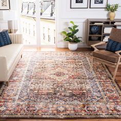 a living room filled with furniture and a rug on the floor in front of a window