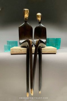 two bronze sculptures sitting on top of each other