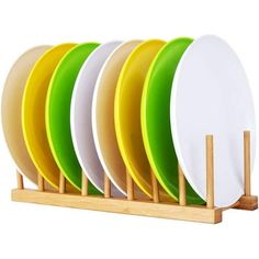 five plates are stacked on a wooden stand with four different colored plates in front of them