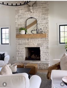 a living room filled with furniture and a fire place under a mirror on the wall