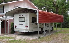 an rv parked in front of a house with a carport attached to the roof