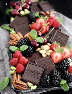 an assortment of chocolates, berries and nuts on a platter