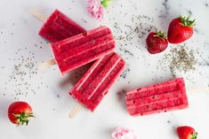 three popsicles with strawberries and flowers on them