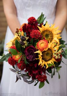 a bride holding a bouquet of sunflowers and other flowers