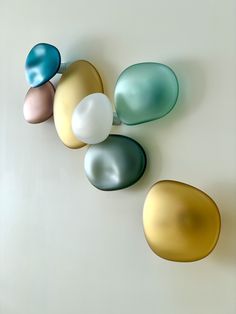 four different colored eggs sitting next to each other on top of a white countertop