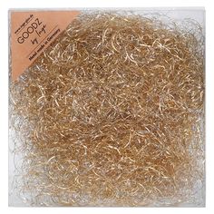 some gold colored metal wire in a plastic bag on a white background with a brown tag