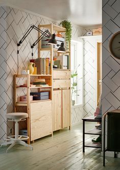 a room with wooden floors and shelves filled with books, plants and other things on top of them