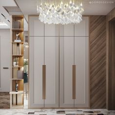 a large white closet with a chandelier hanging from it's ceiling next to a bookshelf