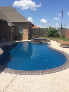 a backyard with a swimming pool and patio furniture