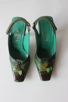 These Prada shoes are absolutely incredible and would make a great addition to anyones closet. shoes are in great condition and have limited signs of wear. The heels amazing details including unique curved heal, leather acorn and leaf appliqués, and a Velcro strap. Shoes are labeled as a EU 35.5 Vintage Green Round Toe Heels, Vintage Green Heels With Round Toe, Green Leather Sole High Heels, Green Leather Heels With Sculpted Heel, Vintage Almond Toe Green Heels, Vintage Green Almond Toe Heels, Green Leather Pointed Toe Heels, Green Leather Heels With Pointed Toe, Green Pointed Toe Heels With Leather Sole