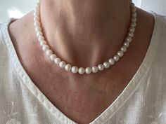 "This classic feminine necklace is made with high quality genuine AAA grade white 8mm freshwater pearls. A delicate, feminine & classy necklace perfect for all occasions. These pearls have high luster, are smooth, perfectly calibrated, and uniform in size. Freshwater pearls symbolize purity, harmony and humility. Pearls are organic gems that are officially the oldest gem coveted by man for their beauty and have been used as a trade commodity for thousands of years. Freshwater pearls were found i Delicate Round Bead Pearl Necklace For Formal Occasions, Delicate Formal Pearl Necklace With Round Beads, Classic Round Bridal Necklace With Pearl Charm, Delicate White Pearl Necklace For Formal Occasions, White Akoya Pearl Round Bridal Necklace, White Akoya Pearl Bridal Necklace, Round White Akoya Pearl Bridal Necklace, Classic White Pearl Pendant Bridal Necklace, Classic White Round Beads Bridal Necklace