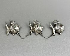 This charming old Mexican silver brooch features three hollow handmade fish, two set with turquoise eyes and one with a coral eye. Each fish measures about 1 inch long, and the three brooches, along with the two connecting chains, measure about 5 1/4 inches long overall. The markings on the backs read Mexico Silver, and I believe this brooch is quite old, possibly from the 1930s. The middle fish has an early rolling safety catch, and the outer two fish have C clasps. The pin stems are steel. Thi Old Mexico, Turquoise Eyes, Two Fish, Silver Brooch, Estate Jewelry, Brooch Pin, Brooches, 1 Inch, Patina