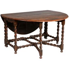 an old wooden table with twisted legs and a large oval shaped center piece on the top