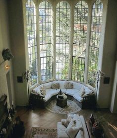 a living room filled with furniture and large windows