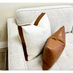 two pillows sitting on top of a white couch