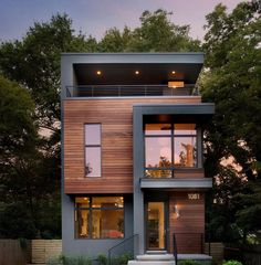 a modern house with stairs leading up to the second floor and large windows on top