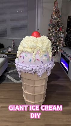 an ice cream cone with white frosting and sprinkles on top, in front of a christmas tree