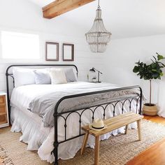 a bedroom with white walls and wood floors