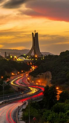 an image of a highway going through the city at night time with light trails in the foreground