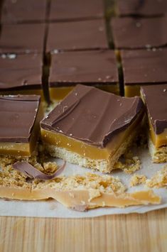 pieces of chocolate and peanut butter bars on top of a cutting board with one cut in half