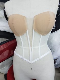 a mannequin wearing a white and beige corset