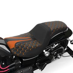 a close up of a motorcycle on a white background with orange and black leather seats