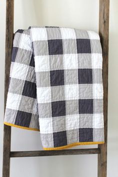 a black and white checkered blanket sitting on top of a wooden ladder