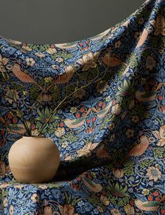 a wooden vase sitting on top of a blue cloth