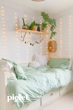 a bed with green sheets and pillows in a room decorated with string lights, potted plants and other decorations