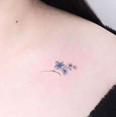 a close up of a woman's shoulder with a flower tattoo on her left side