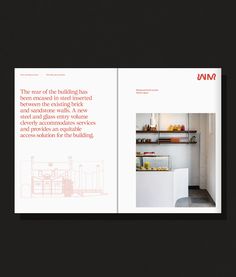 an open book showing the inside of a kitchen with white cabinets and red lettering on it