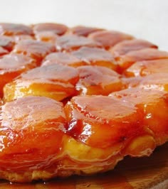 a pineapple upside down cake sitting on top of a cutting board with syrup all over it