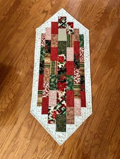 a close up of a patchwork quilt on a wooden floor